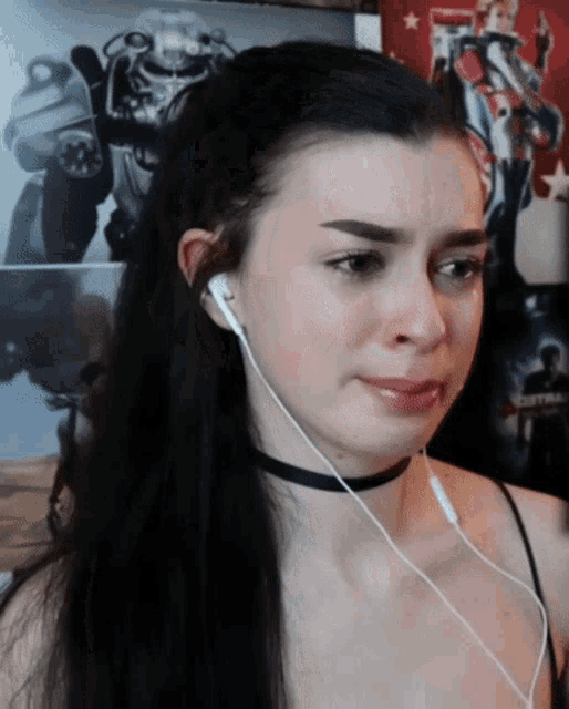 a woman wearing headphones is crying in front of a poster of a robot