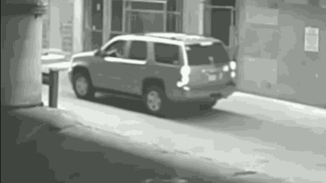a black and white photo of a suv parked in a parking lot