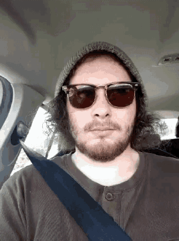 a man with a beard wearing sunglasses and a hat
