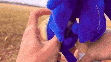 a person is holding a stuffed animal in their hand