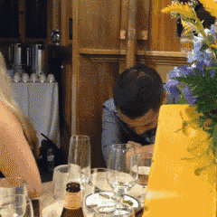a man sitting at a table with a bottle of beer
