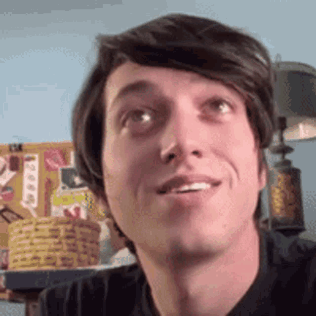 a close up of a man 's face with a lamp in the background .
