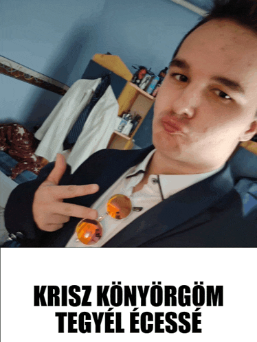 a man in a suit giving a peace sign with the words kriszkonyorgom