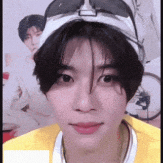 a young man wearing a hat and sunglasses looks at the camera .