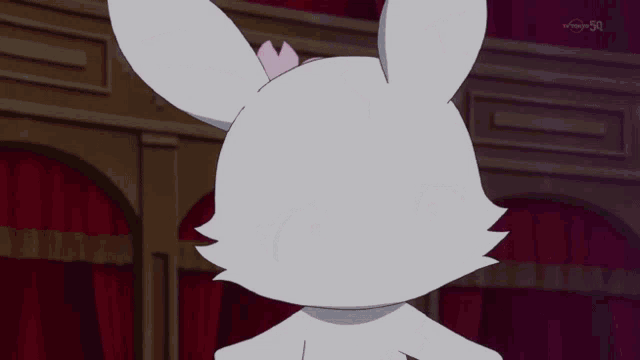 a white rabbit with a pink flower in its ear and a red star on its head