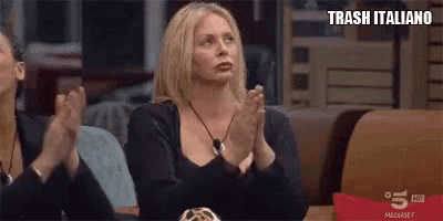 a woman is sitting at a table clapping her hands in a restaurant .