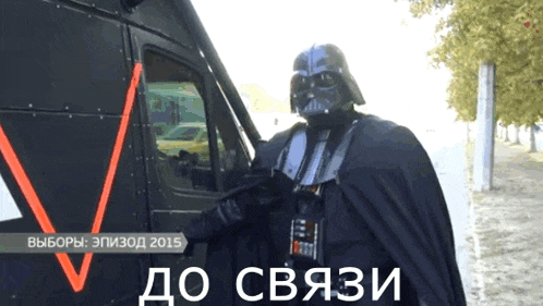 a man in a darth vader costume is standing next to a black vehicle