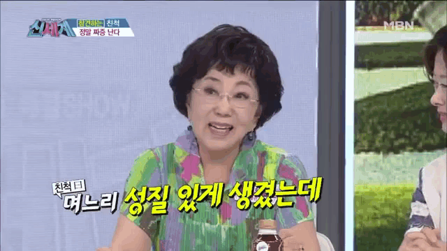 a woman in a colorful shirt is talking on a tv show with mbn written on the bottom