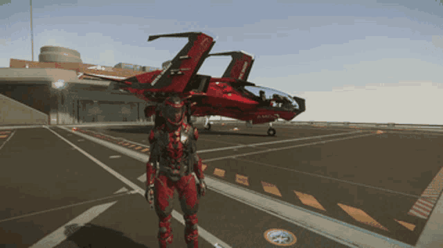 a man in a red suit stands on a runway next to a red jet with the number 7 on it