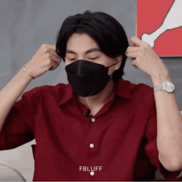 a man wearing a red shirt and a black mask has the word f8luff on the bottom left