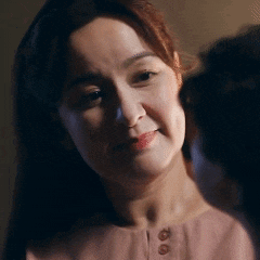 a close up of a woman 's face with a man behind her looking at her .