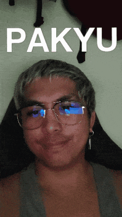 a man wearing glasses and earrings is smiling with the word pakyu behind him