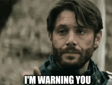 a man with a beard is warning someone that he is warning them .