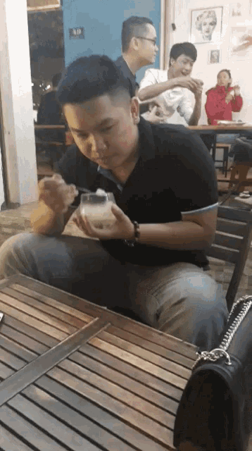 a man sitting at a table with a spoon in his mouth