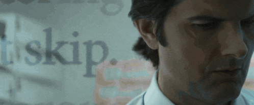 a close up of a man 's face with the word skip behind him