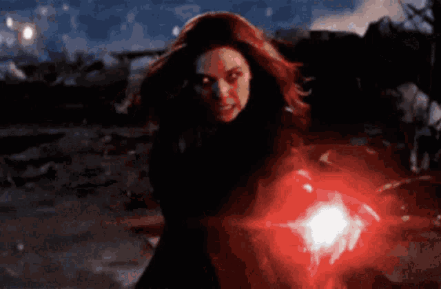 a woman is holding a red light in her hand