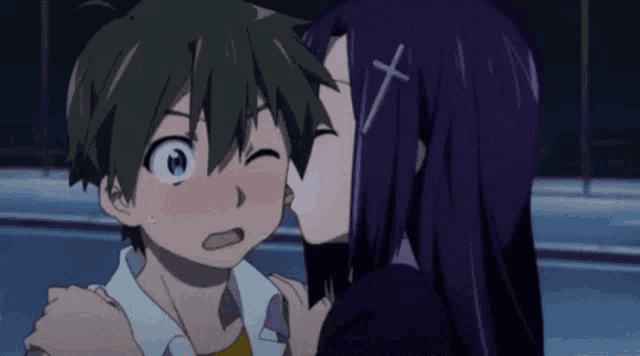 a girl with a cross on her head kisses a boy on the cheek