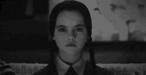 a black and white photo of a girl with pigtails and a collared shirt .