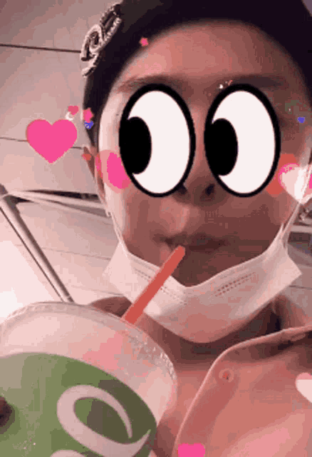 a person wearing a face mask is drinking a smoothie