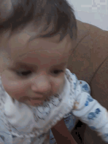 a baby laying on a couch with a blanket that says ' i love you ' on it