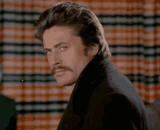a man with a mustache wearing a black jacket