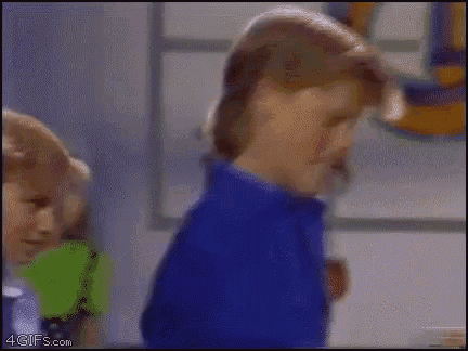 a man in a blue shirt is standing next to a boy in a green shirt ..