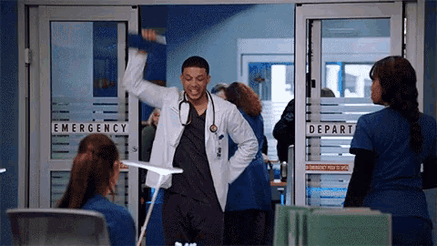a man in a lab coat stands in front of an emergency exit