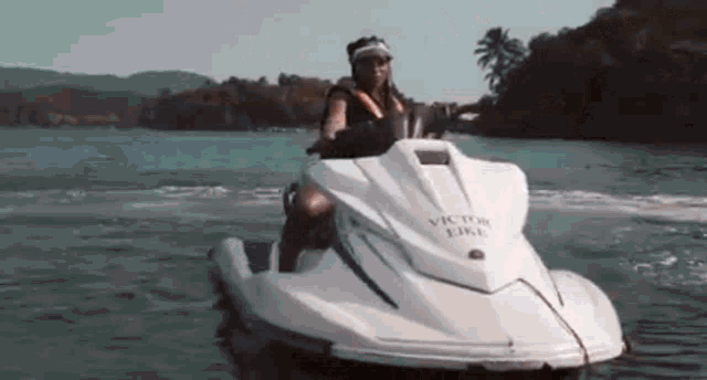 a woman is riding a jet ski on the water .