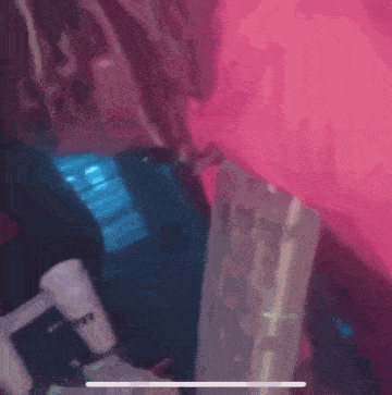 a person is sitting in a chair with a pink background .