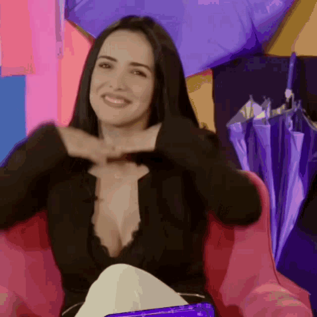 a woman in a very plunging black top is smiling