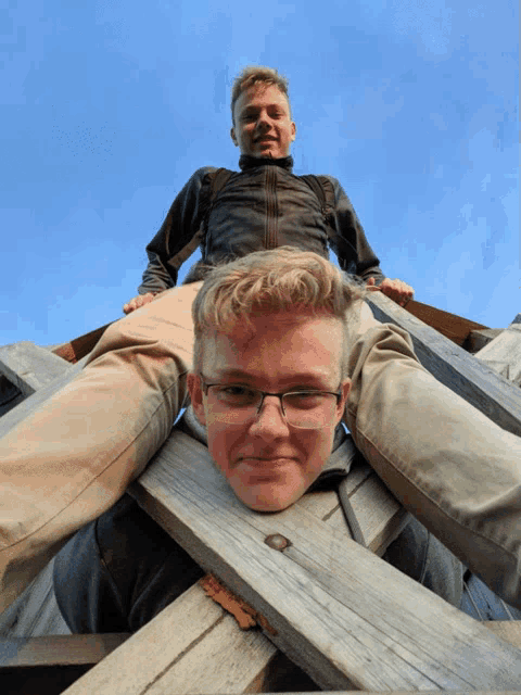 two young men are posing for a picture with one of them laying on the other 's shoulders