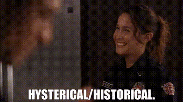 a woman in a police uniform is standing in front of a refrigerator and pointing at it .
