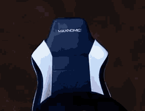 a man with glasses is sitting in a chair and smiling .