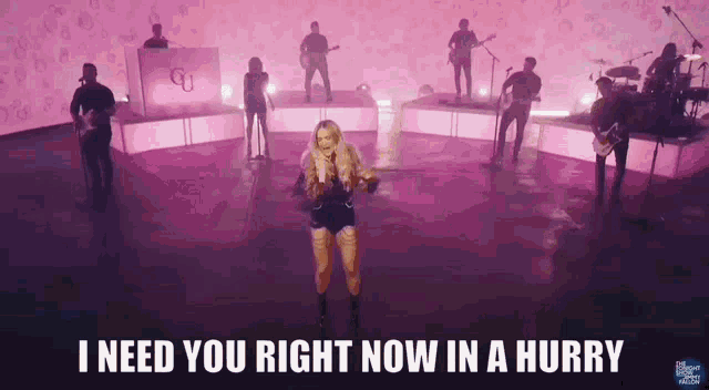 a woman singing in front of a band with the words " i need you right now in a hurry " on the bottom