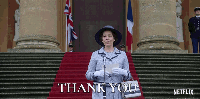 a woman stands on a set of stairs holding a piece of paper that says thank you on it