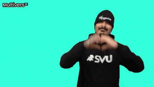 a man making a heart shape with his hands in front of a green background that says multiverse
