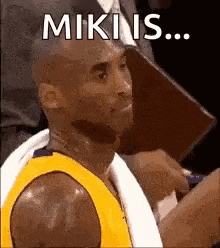 a basketball player is sitting in the stands with a towel around his neck and a towel around his neck .