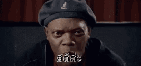 a man wearing a beret is making a funny face and talking in a foreign language .