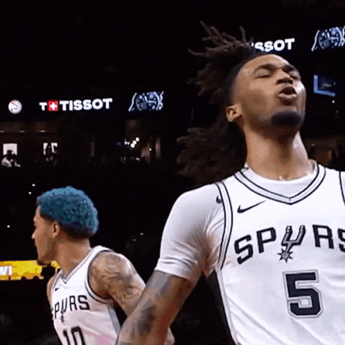 a basketball player with the number 5 on his jersey is standing next to another player