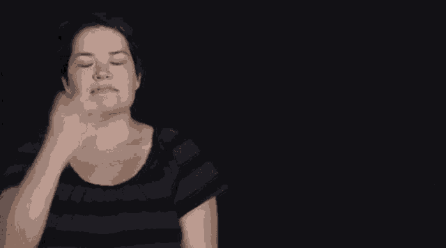 a woman in a striped shirt is making a funny face while making a funny face .