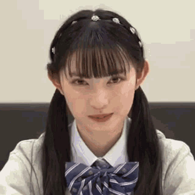 a girl with pigtails and a bow tie is sitting at a table .