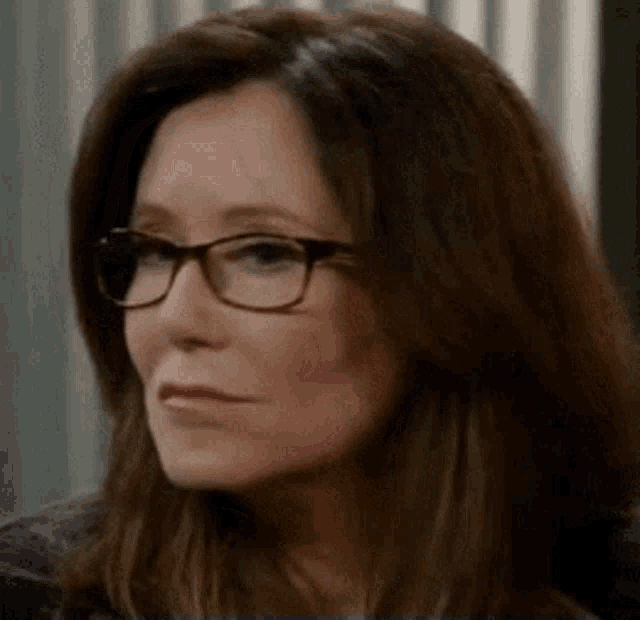 a woman wearing glasses is making a funny face .