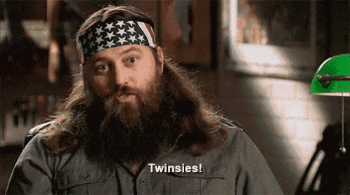 a man with a beard wearing an american flag headband says twinsies .