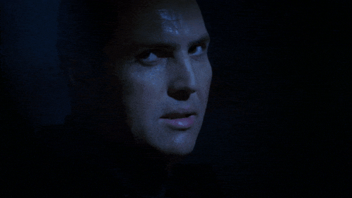 a man 's face is shown in a dark room