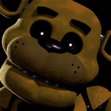 a close up of a yellow teddy bear 's face with black eyes .