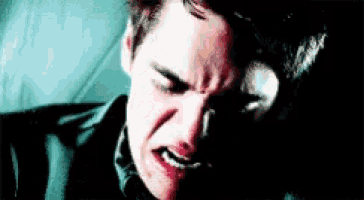 a close up of a man 's face with a tear running down his cheek .