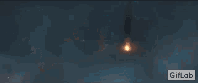 a gif of a monster in a dark room with a fire coming out of it .