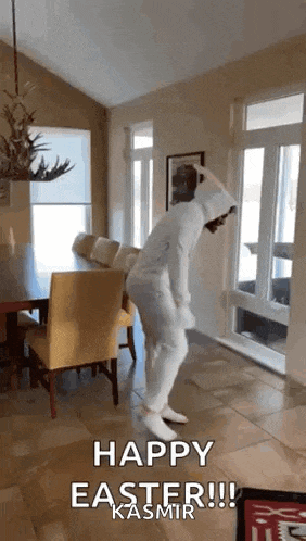 a person in a bunny costume is dancing in a living room with the words `` happy easter ! ''