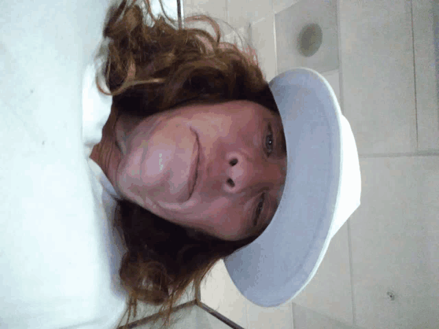 a woman with long hair wearing a white hat and a white shirt