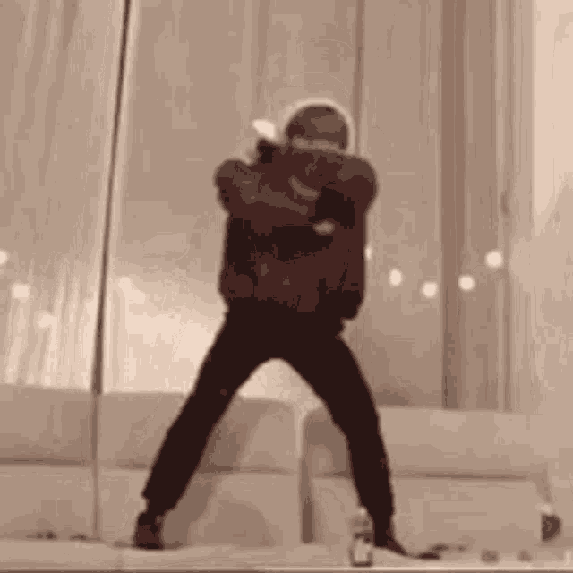 a group of people are dancing in a living room in front of a window .